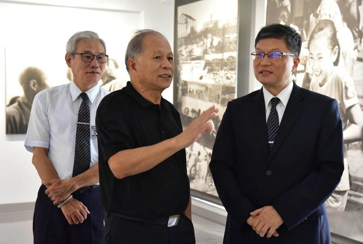 攝影師阮義忠向慈濟慈善基金會副執行長劉效成導覽照片，並說明每張照片的故事。