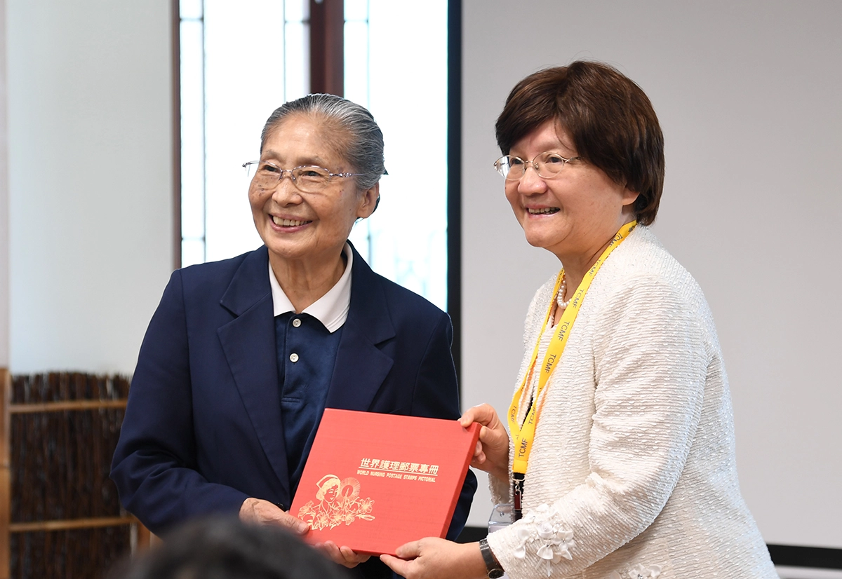 考試委員李選（右）贈與林碧玉副總執行長（左）郵票專冊。