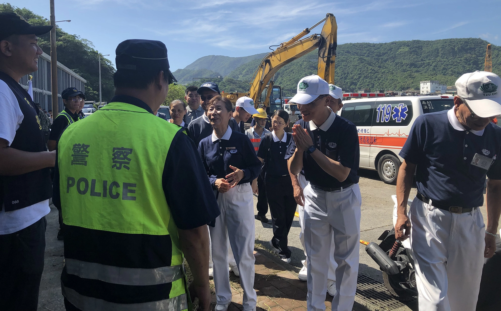 慈濟慈善志業執行長顏博文(左)於10月2日一早前往南方澳現場，向救災人員致意。
