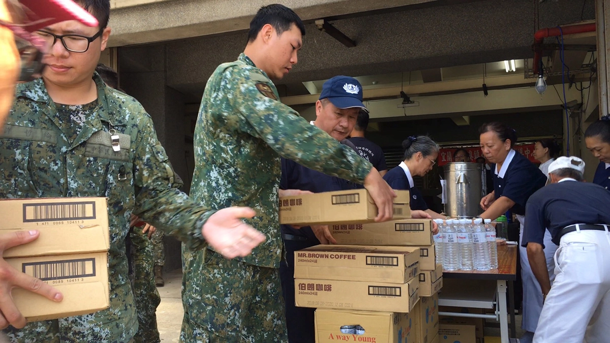 慈濟志工進駐「南方澳大橋斷橋事故」現場成立服務中心，國軍協助慈濟志工搬運物資。
