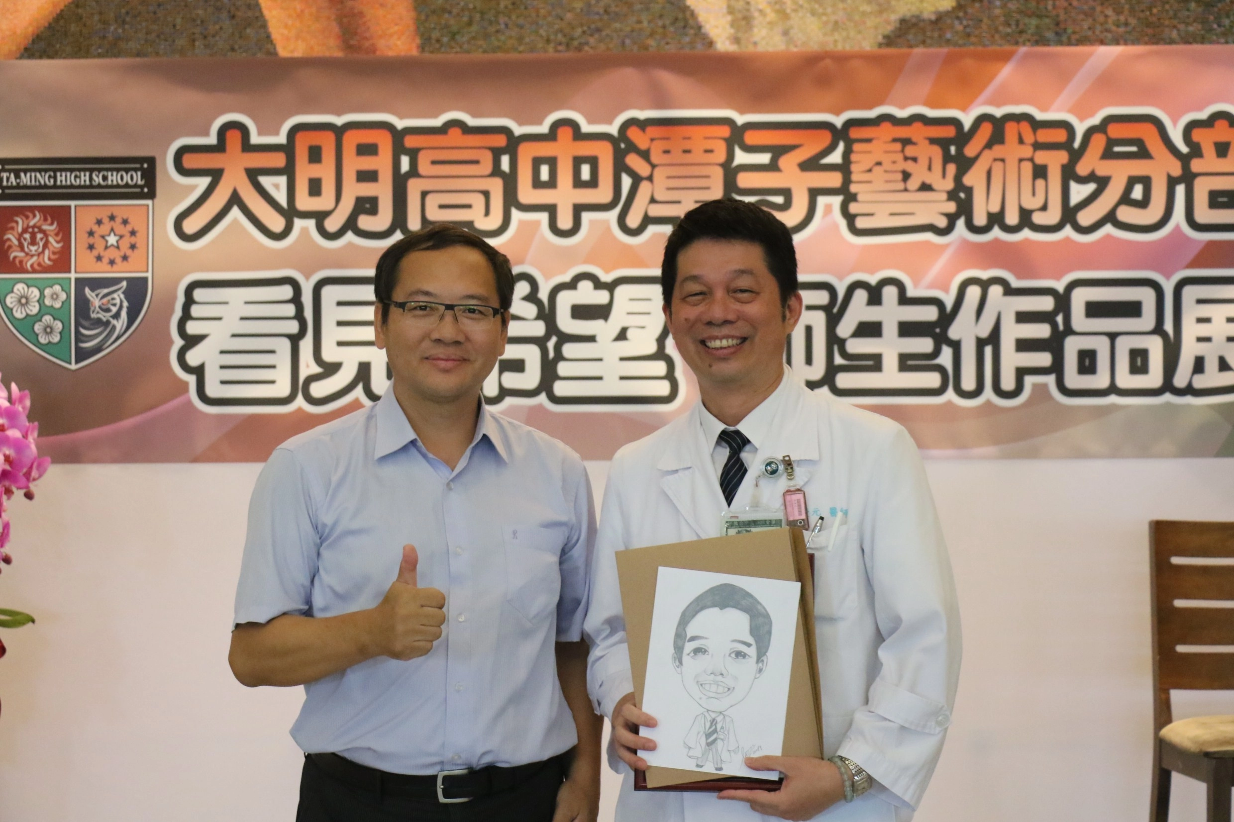 大明高中校長吳原榮（左) 致贈感謝狀及素描給臺中慈濟醫院社區健康中心主任陳慶元。