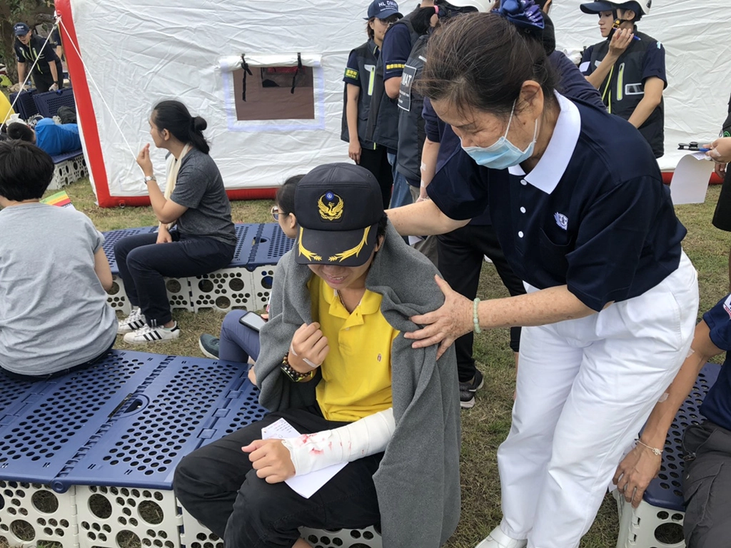 108年東區北區災難醫療隊聯合演練15日上午在德興運動公園舉辦，為期3天2夜的災難醫療演練，全面實境模擬，圖為慈濟志工為模擬傷者披上毛毯，陪伴膚慰。