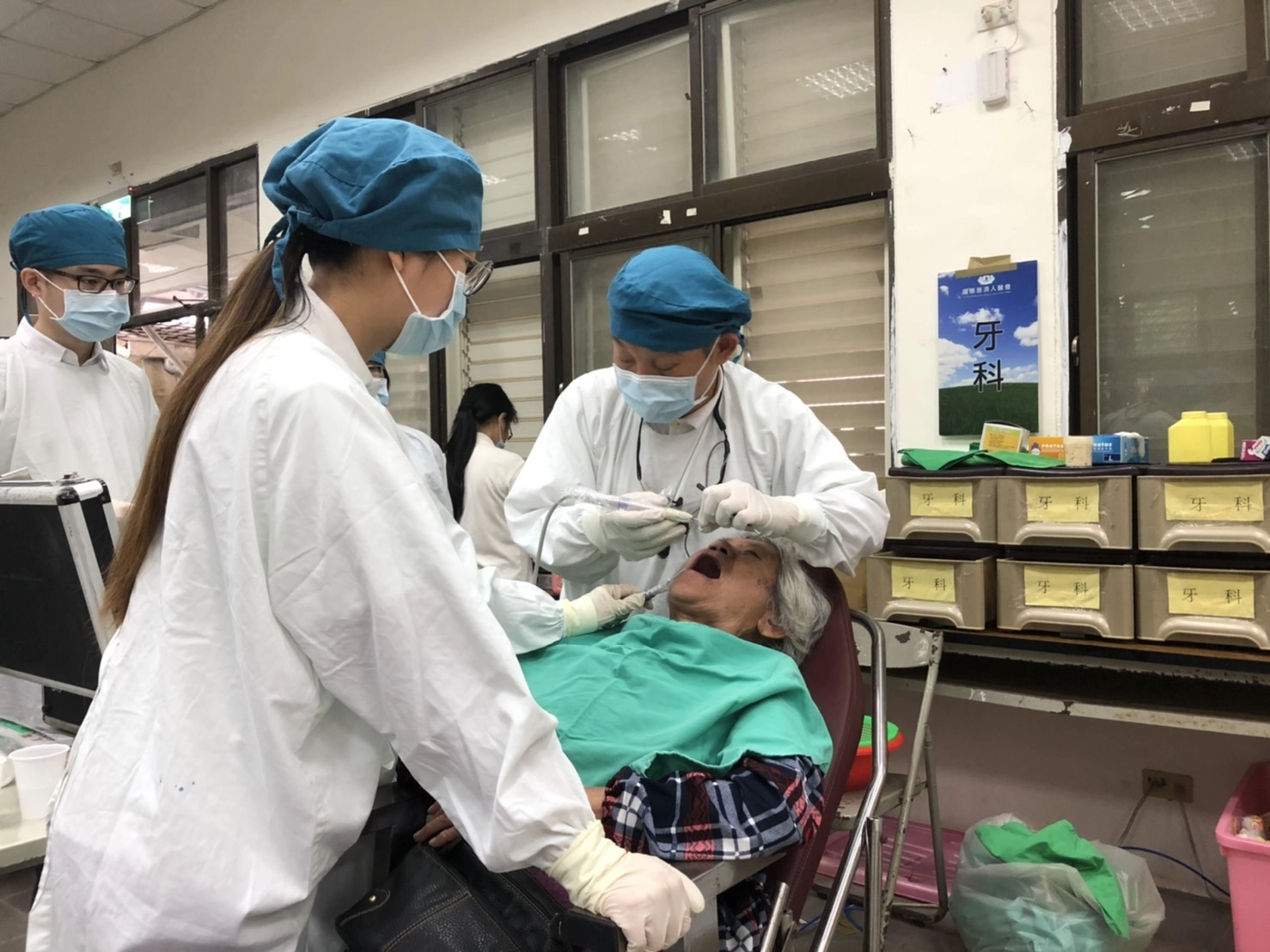 花蓮慈濟醫院李彝邦醫師專注的幫長者檢查口腔，也同時衛教保健牙齒的重要性。(慈濟基金會提供)