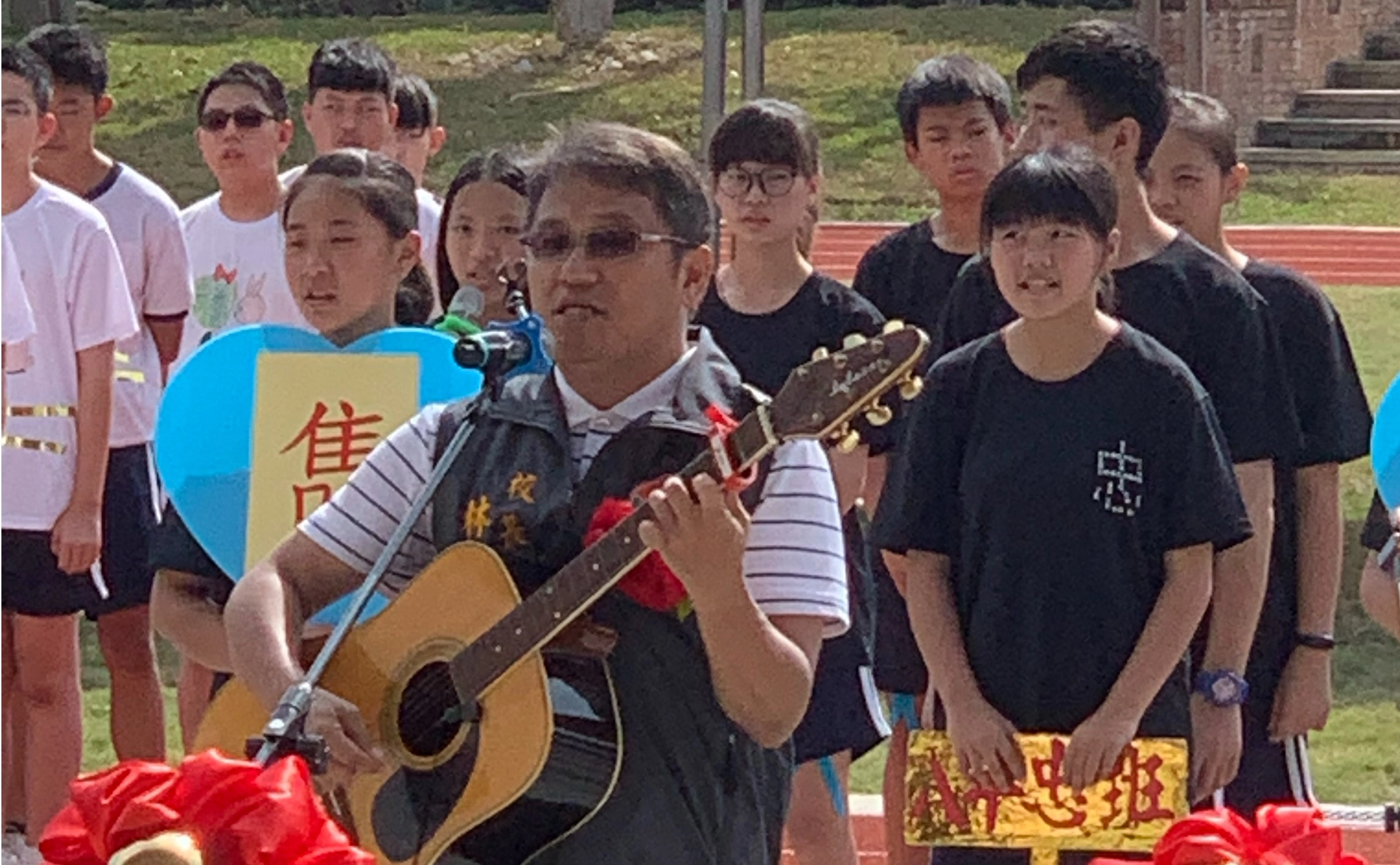 圖說：苗栗縣造橋國中林育伸校長帶領學生唱出自行創作曲「築心雋永」，清亮感恩的旋律，是慈濟與大家共同對學童在安全校園「愛的守護、善的循環」共鳴之聲。（圖：劉寶菊攝）