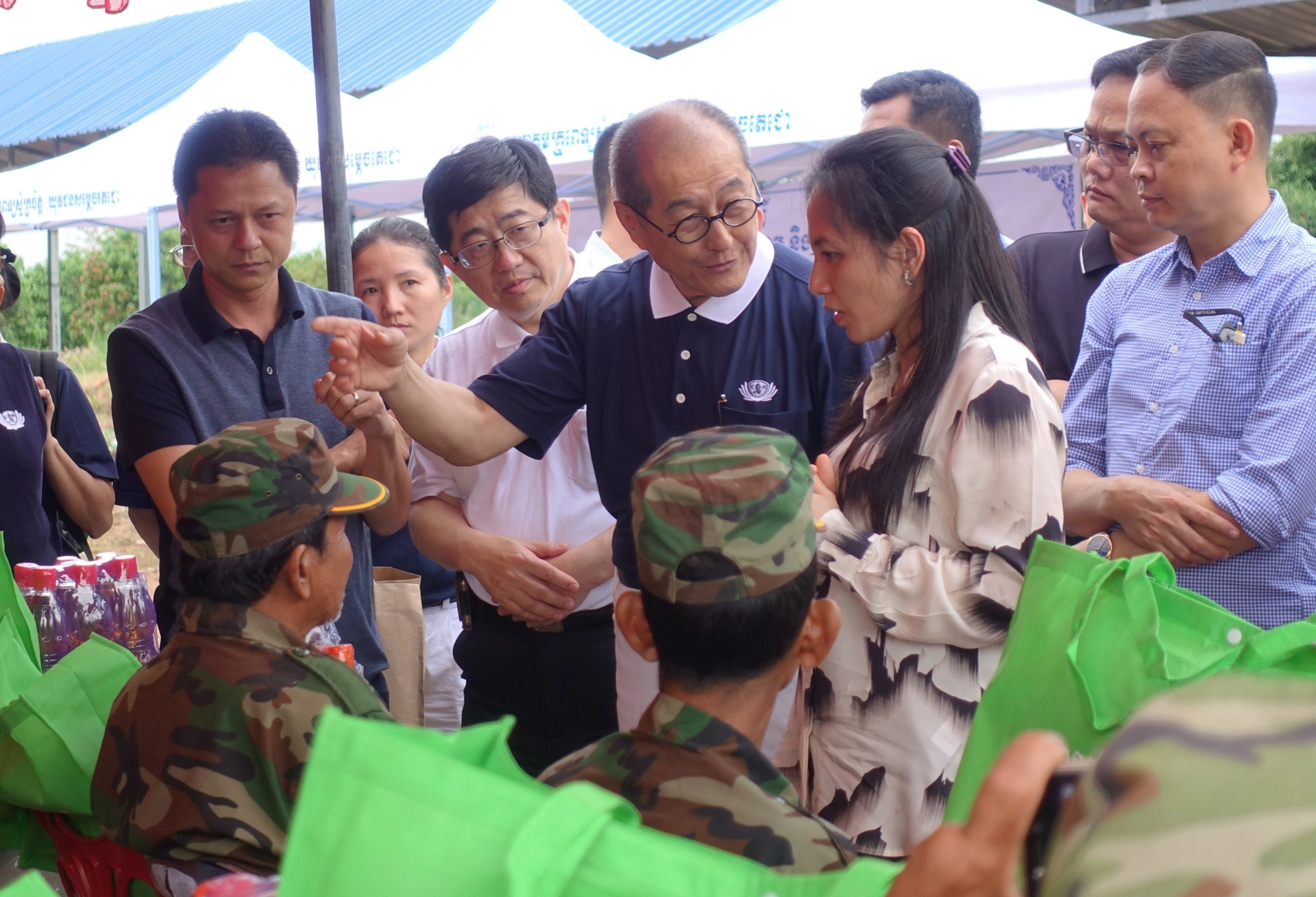 當地村民高文淵(坐者，左一)向貝占莫妮洪馬內夫人(站者，右二)表示身上還有砲彈，慈濟基金會劉濟雨副執行長(站者，左三)、大林慈濟醫院林名男副院長(站者，左二)建議隔天到慈濟義診的地方看診。(攝影：陳誼謙)