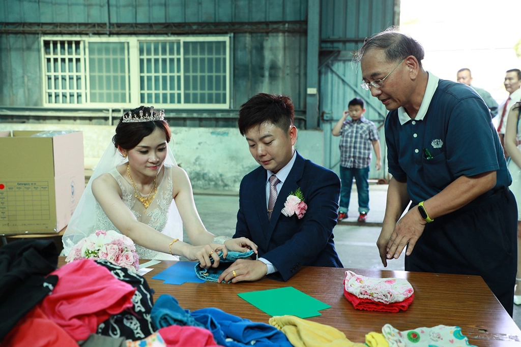 張毓哲與新婚的妻子卓雨親一起摺同一件衣服，整理募集的衣物，送到莫三比克給當地的孩童。