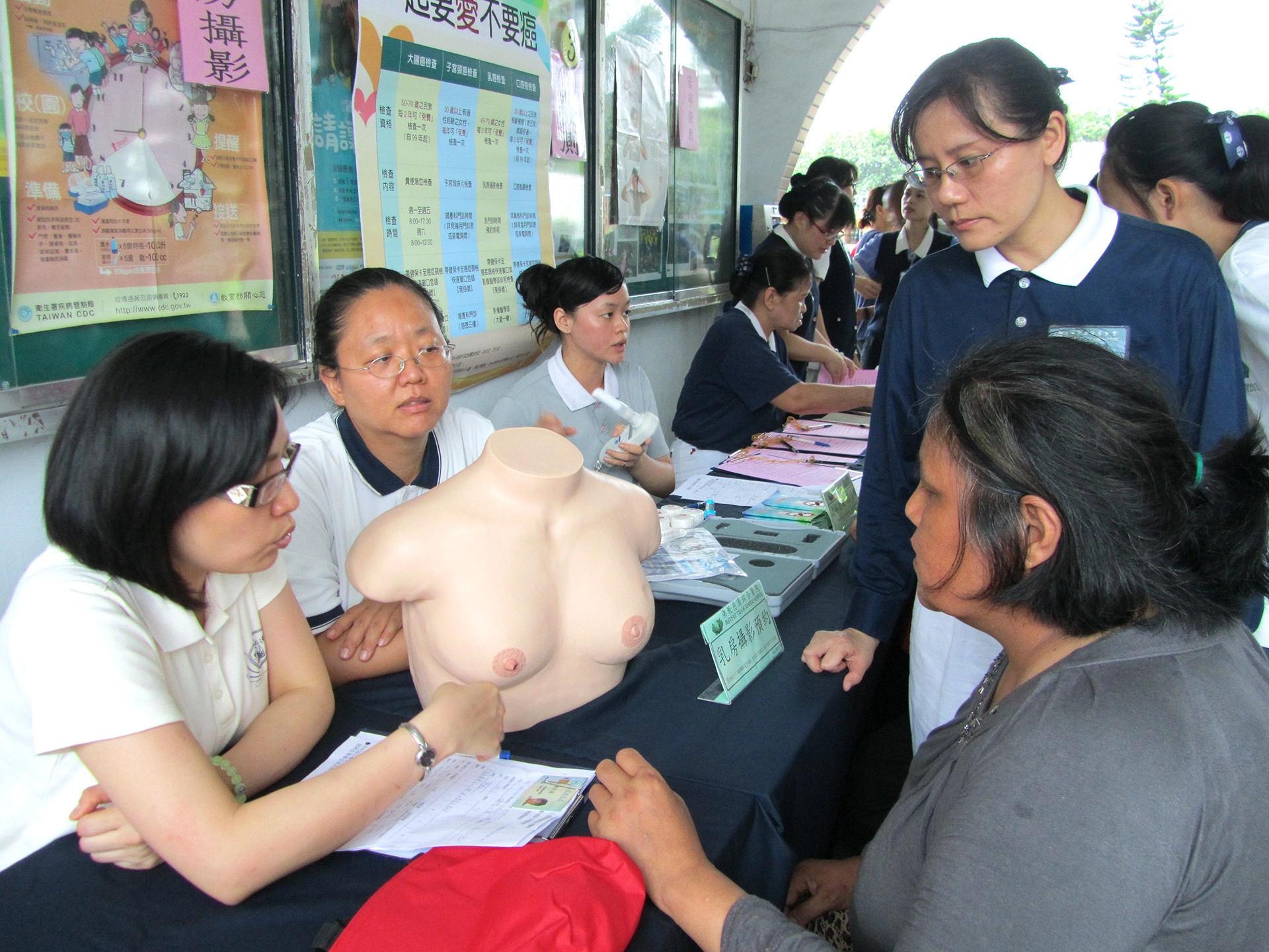 慈濟基金會、花蓮縣衛生局及佳民國小共同舉辦親子健康生活體驗營，希望透過活動將正確的健康概念，傳遞並落實在每一位居民心中。圖：成人健康檢查，醫護人員向居民說明乳房攝影檢查。