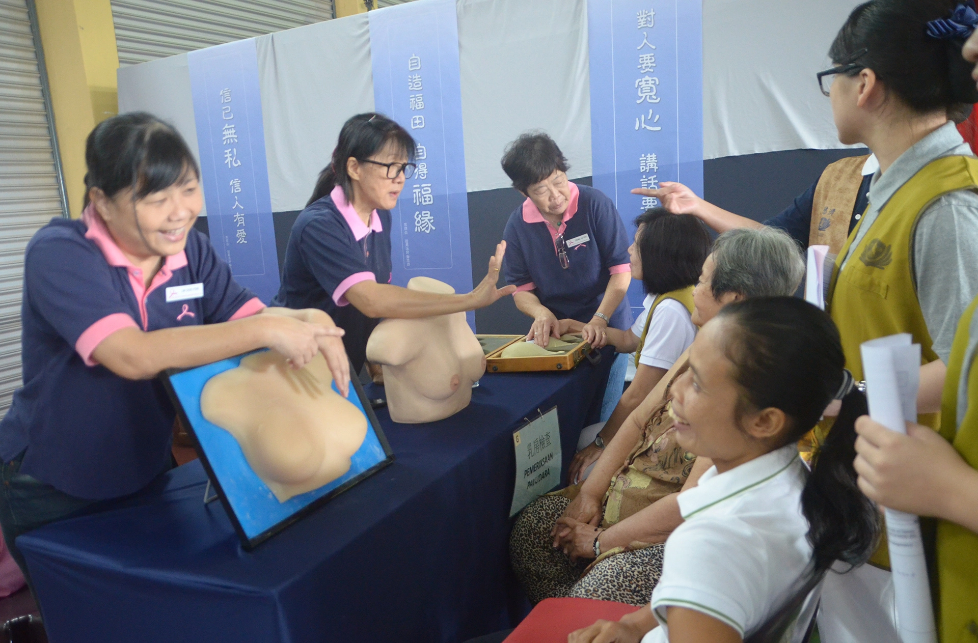 慈濟基金會舉辦健檢活動；乳癌協會義工為民眾講解如何自行檢查乳房。