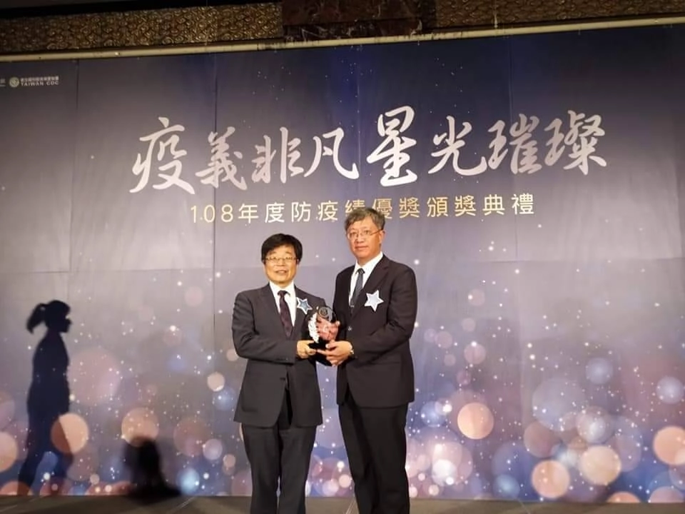 大林慈濟醫院賴俊良副院長（圖右）代表領取衛福部防疫績優非公務類團體獎，由疾管署長周志浩頒獎。