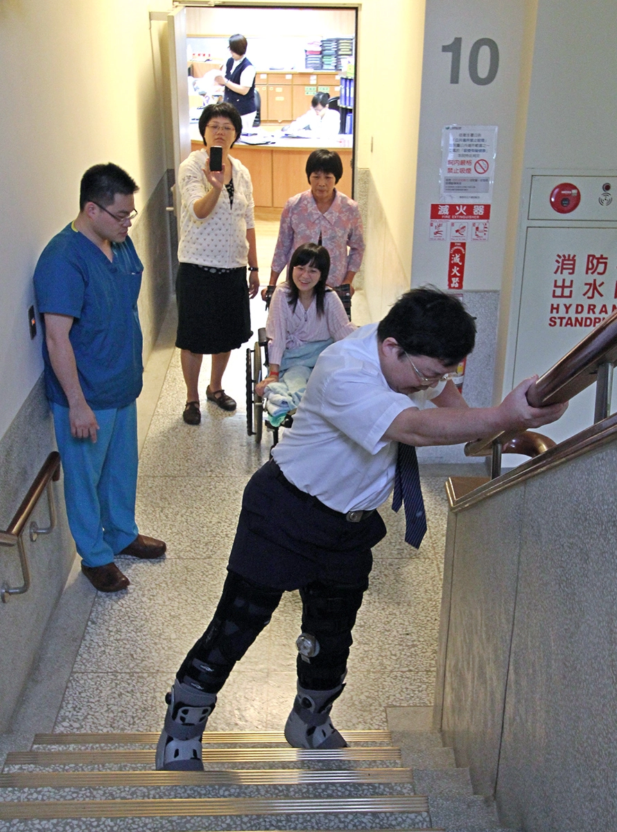 花蓮慈院陳英和名譽院長，親自穿著「氣動式踝護具」示範行走、上下樓梯，模擬陳小姐術後雙腿打直的走路方式。