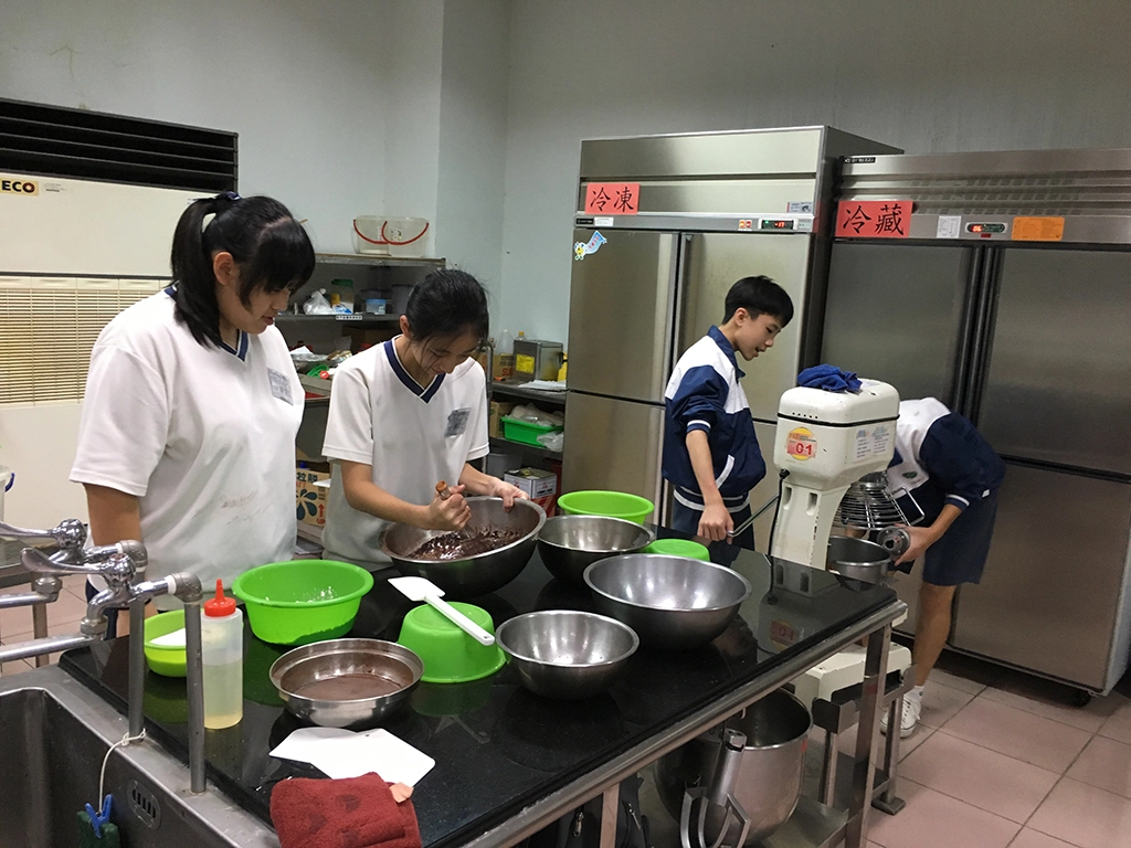學生體驗食品群，首次使用攪拌缸製作巧克力蛋糕捲，認真攪拌巧克力麵糊。
