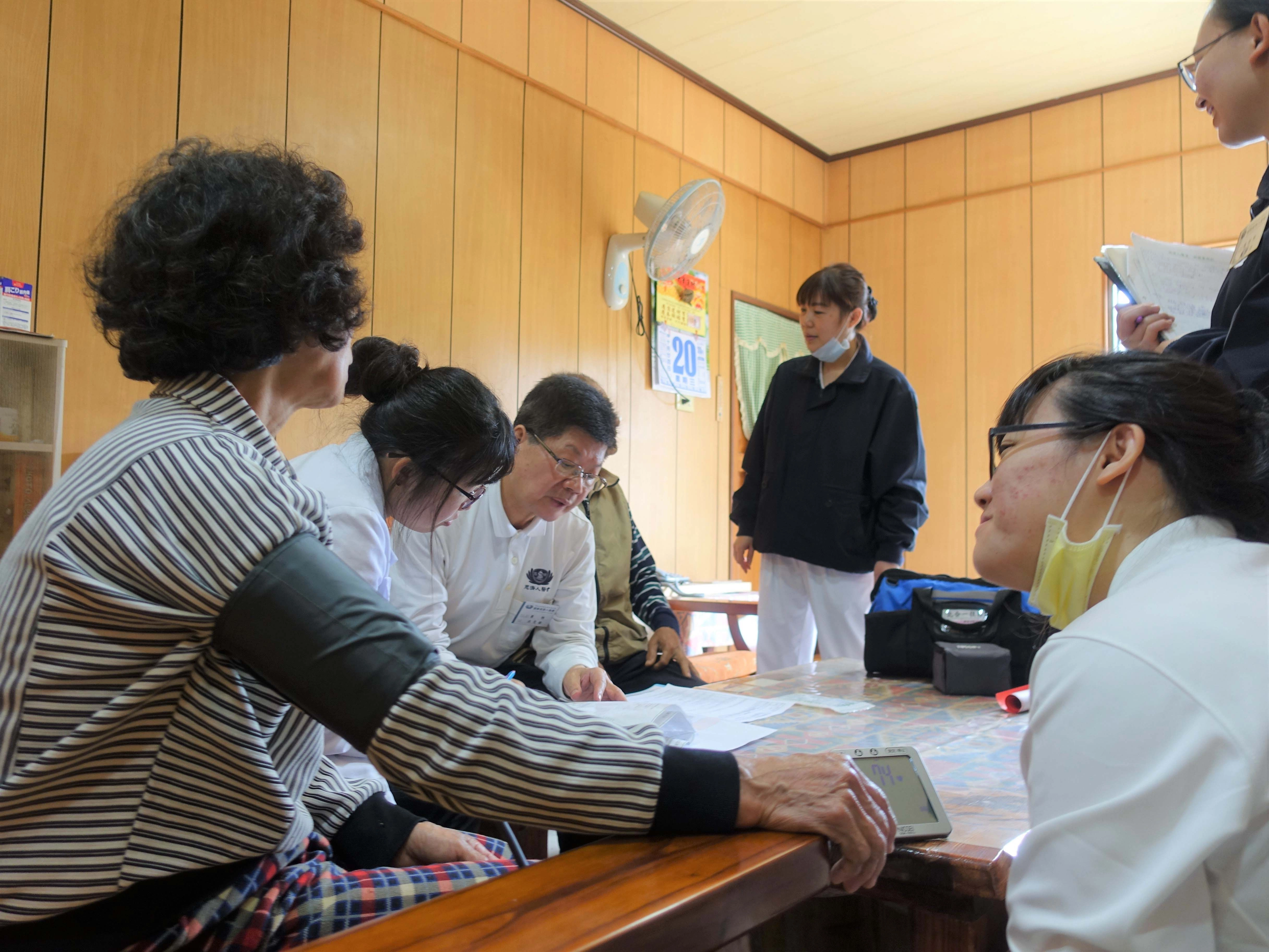慈濟人醫會的醫師、護理師、藥師，以及慈濟志工一起關懷長者，護理師先協助量血壓，醫師、藥師了解長者的用藥。