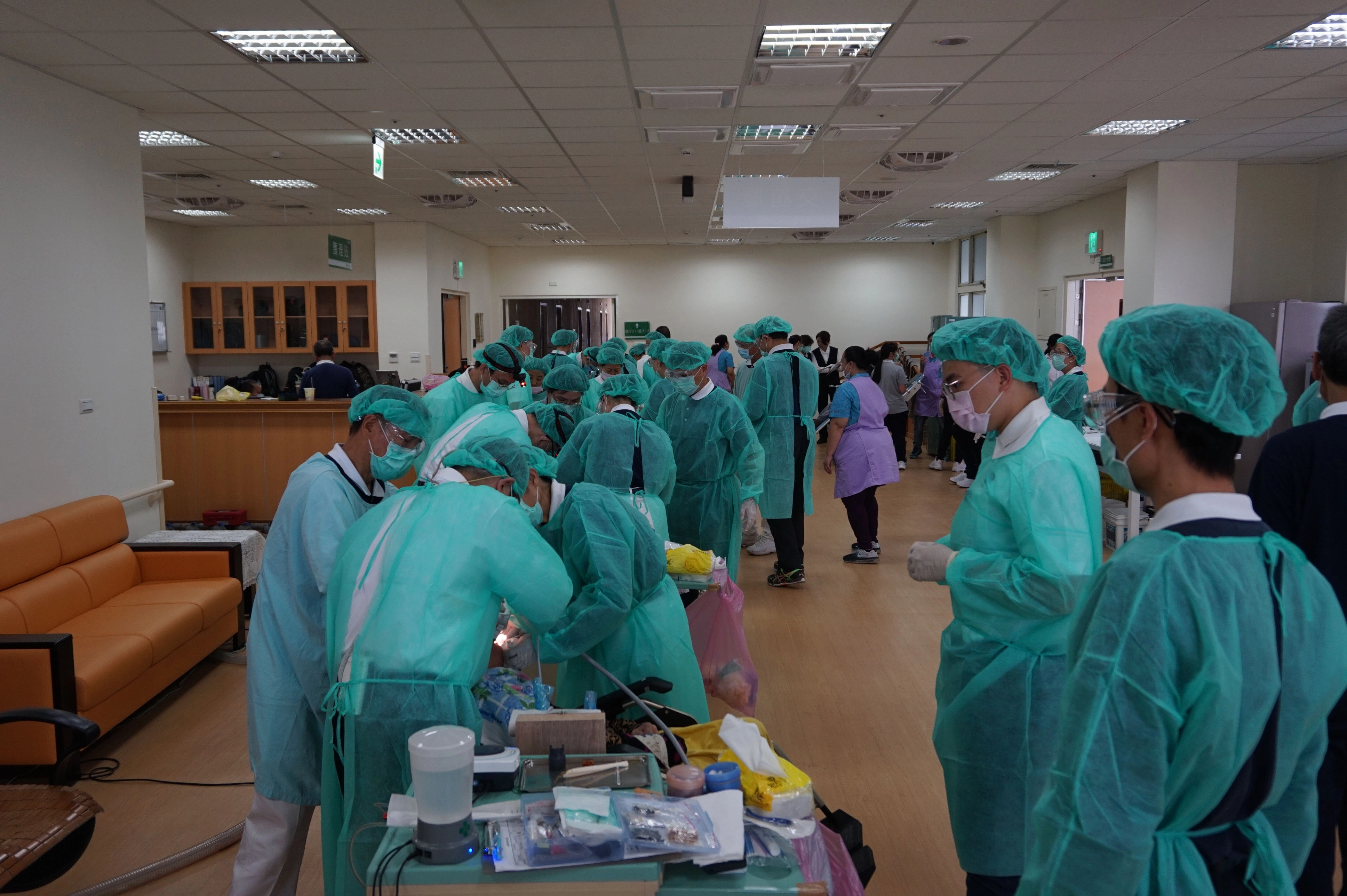臺東仁愛之家2、3樓的交誼廳，全都提供牙科義診服務，透過戶外明亮的光線讓大醫王及志工身上的隔離衣都明亮起來了。