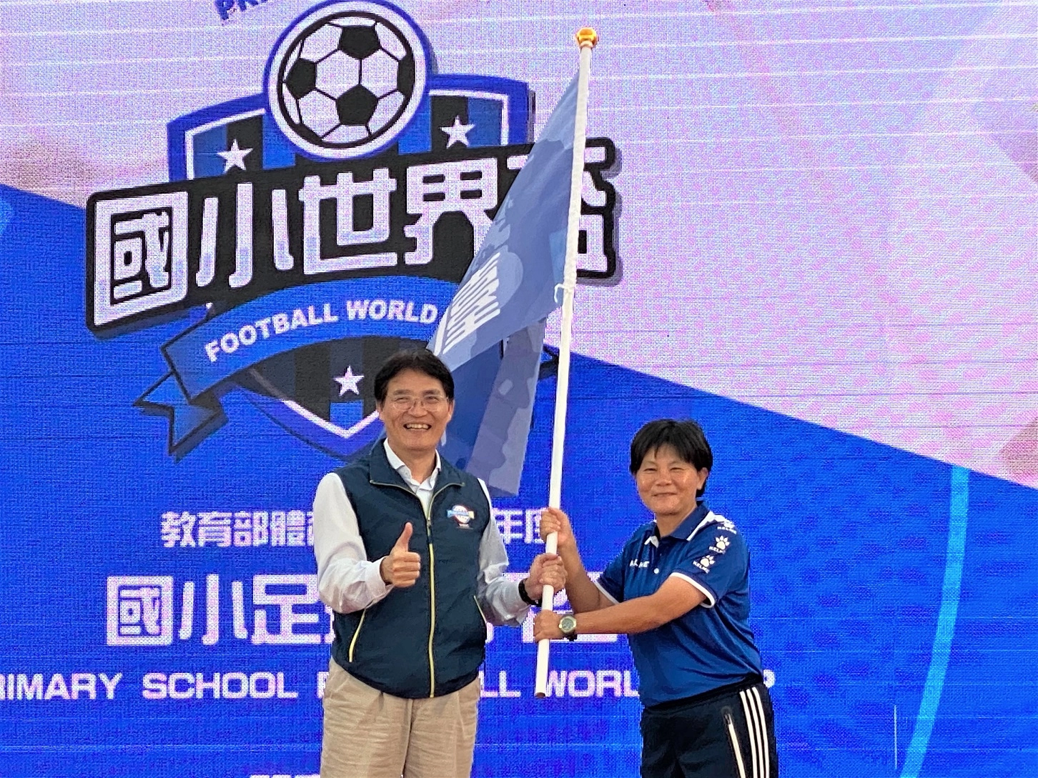 體育署高俊雄署長(左)授旗予臺中市代表國立臺灣體育運動大學呂桂花教授(右)，照片教育部提供。