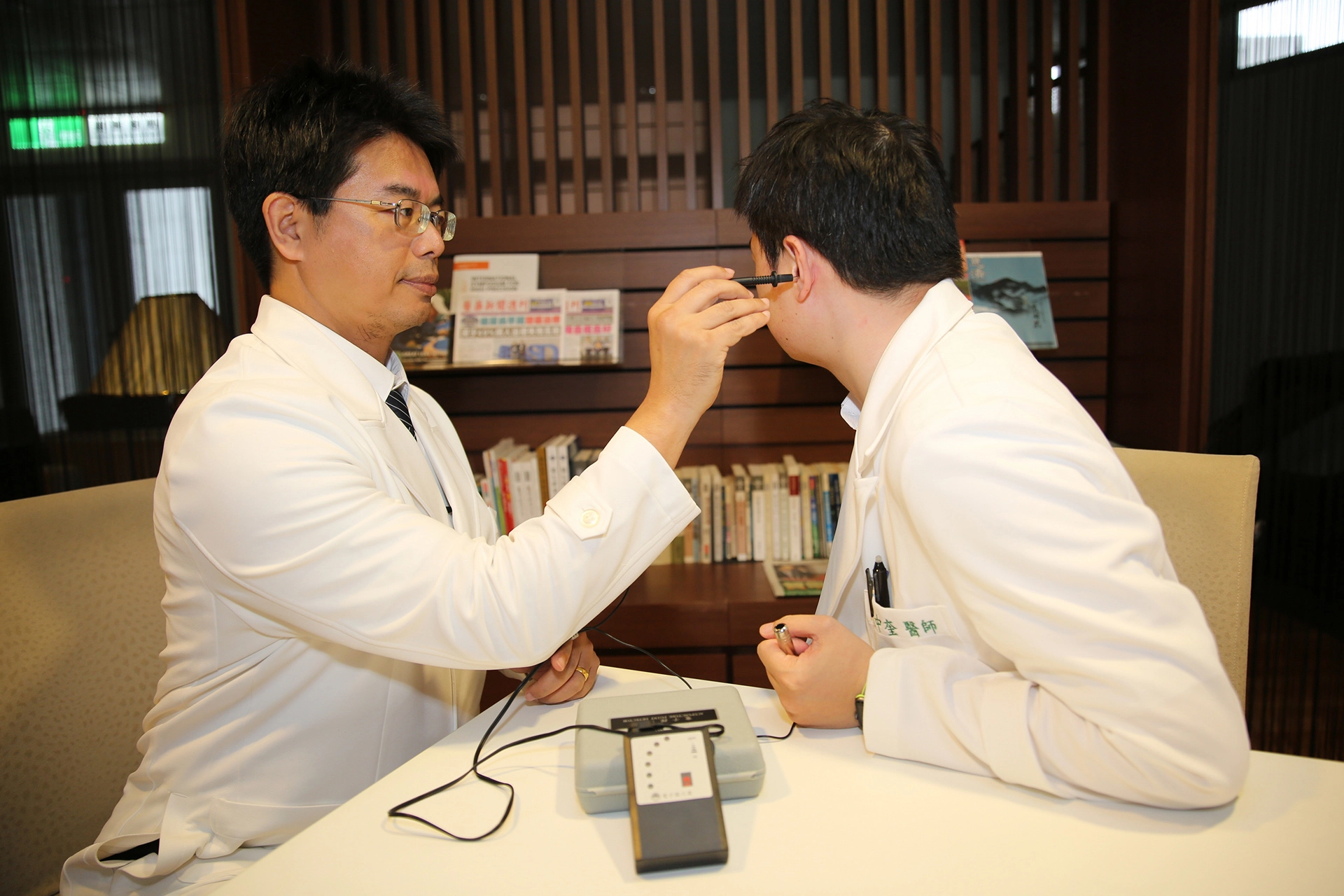 花蓮慈院何宗融副院長(左)示範中醫耳穴健檢。