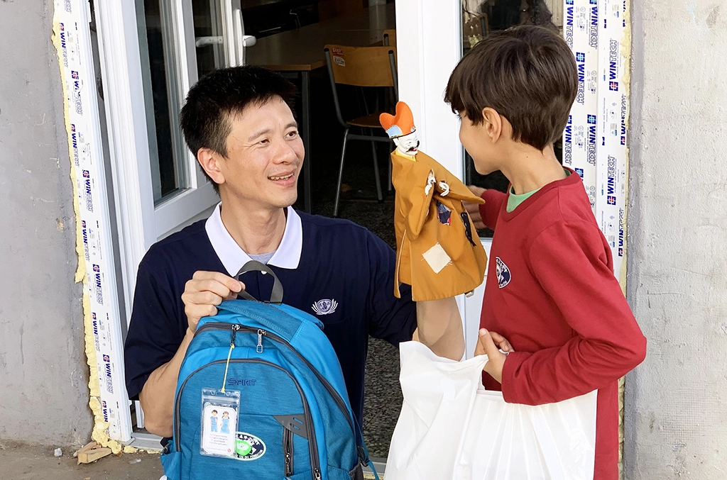 歐洲慈濟志工長期關心滯留在塞爾維亞的各國難民；慈濟志工發放新書包和文具用品給難民孩子。林正中師兄(左)用布袋戲與小朋友互動。