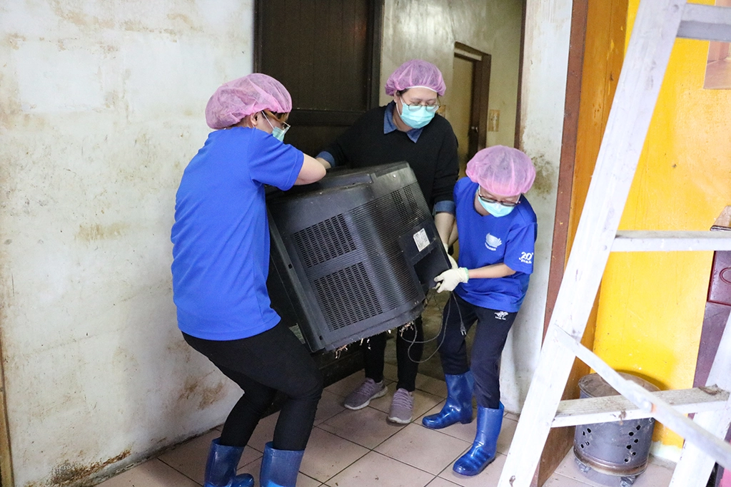 在眾人合力下，將報廢的家電、家具、機車與垃圾扛出，刷洗屋內髒汙油垢、重新油漆牆面等。