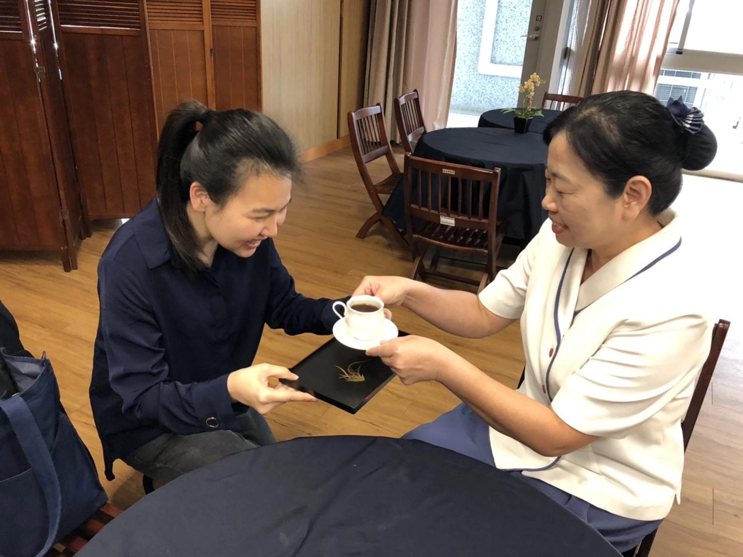 12月21日熊雪妙老師(右)和林同學(左)相約在台中靜思堂，林同學奉茶給老師。