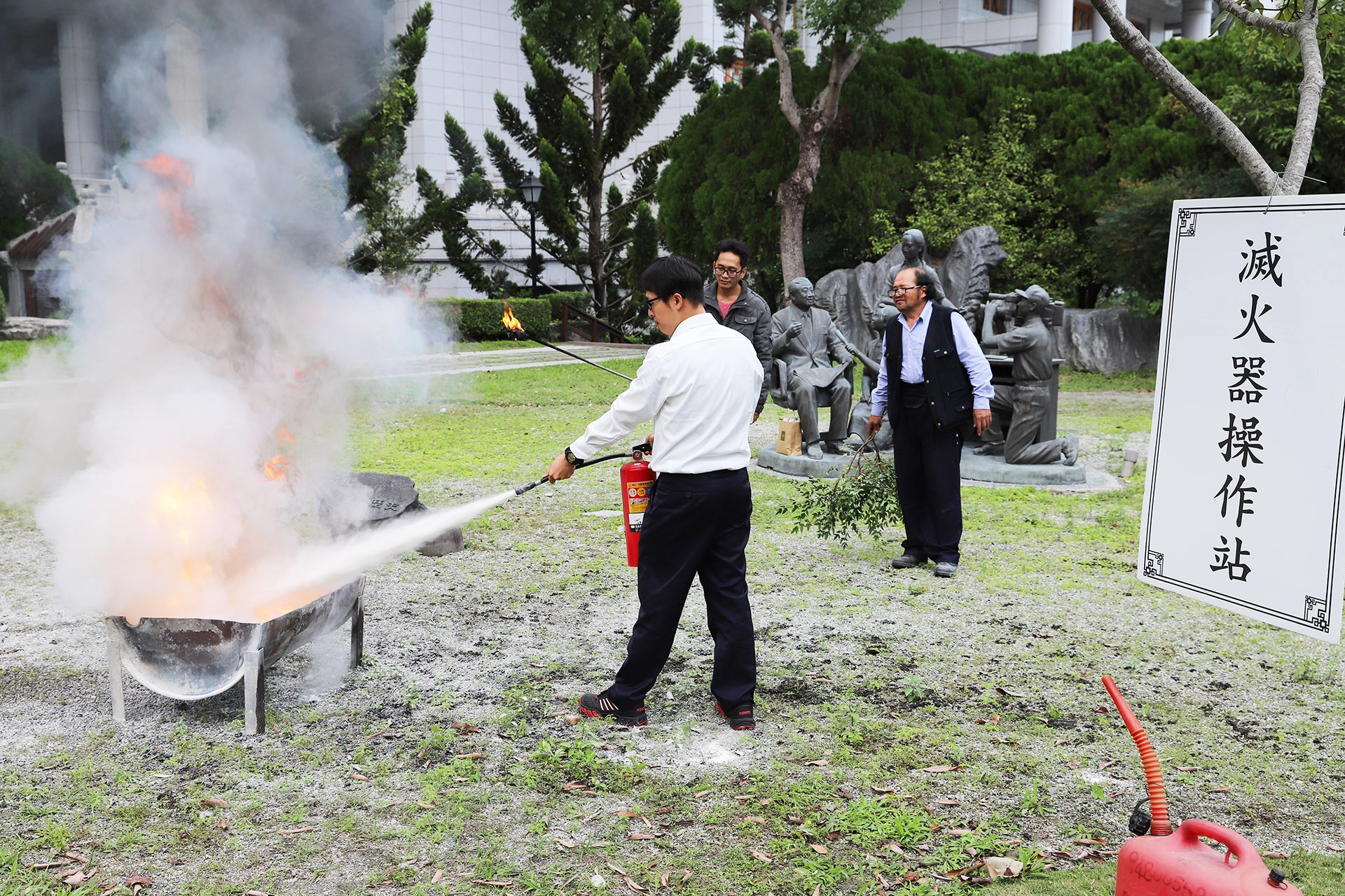 防災宣導講習結束之後，各班班長、副班長分組帶領組員，分別依序進行消防設備操作演練依分組輪站方式進行，圖為乾粉式滅火器滅火操作站操作使用體驗。
