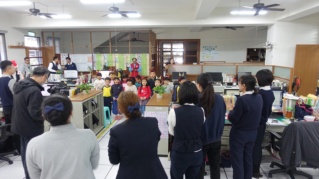 學生在辦公室大聲唱著〈聖誕老公公〉、〈聖誕鈴聲〉，傳遞愛與祝福。