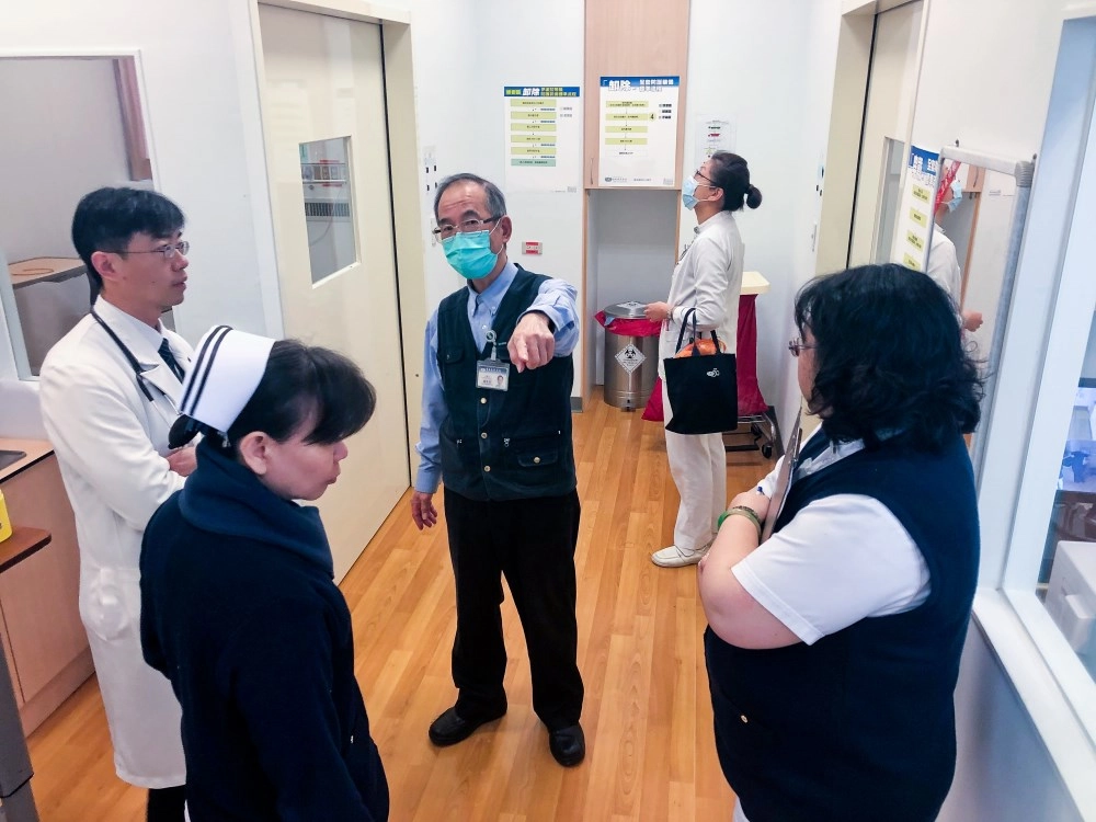 臺北慈院一月二十二日召開院內防疫會議後，感染管制中心吳秉昇醫師（左）、護理與工務團隊，前往急診部發燒篩檢站，確認相關設施設備與後送感染病人動線。