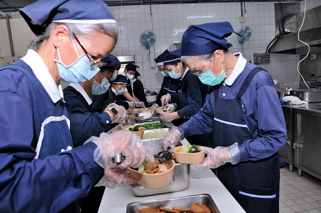 17位慈濟志工在雲林聯絡處中央廚房打餐，準備送往斗南鎮公所。