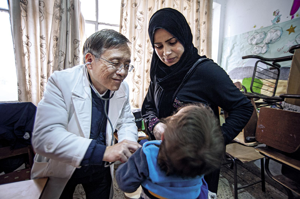 不捨敘利亞難民與孩童生病求助無門，簡守信數度與慈濟醫療團隊前往約旦義診；投入義診二十多年，特殊個案的病因能以長年累積的豐富素養解說。