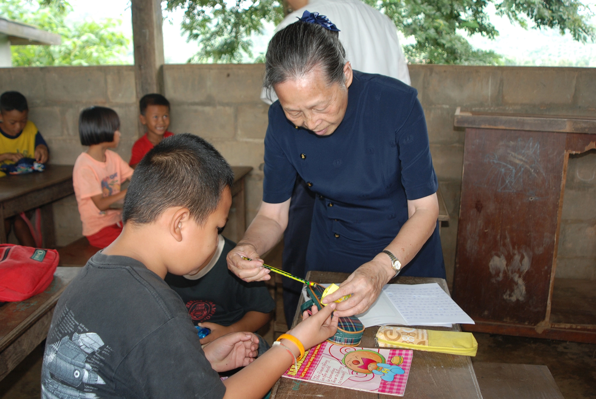 楊月鳳校長一直致力於偏鄉教育，圖為前往泰北小學與學童互動，並贈送來自台灣的愛心鉛筆盒。