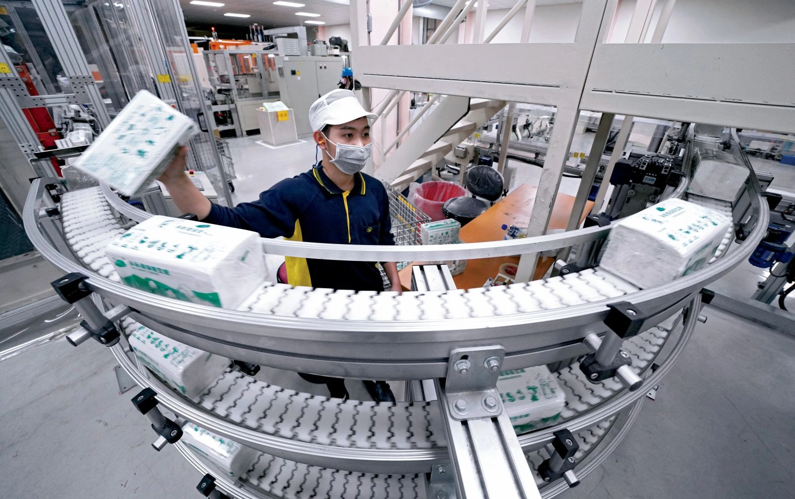 輸送帶上的淨斯環保衛生紙，由回收紙和紙容器下腳料製成，包裝亦採水墨印刷，無毒無味可自然分解。