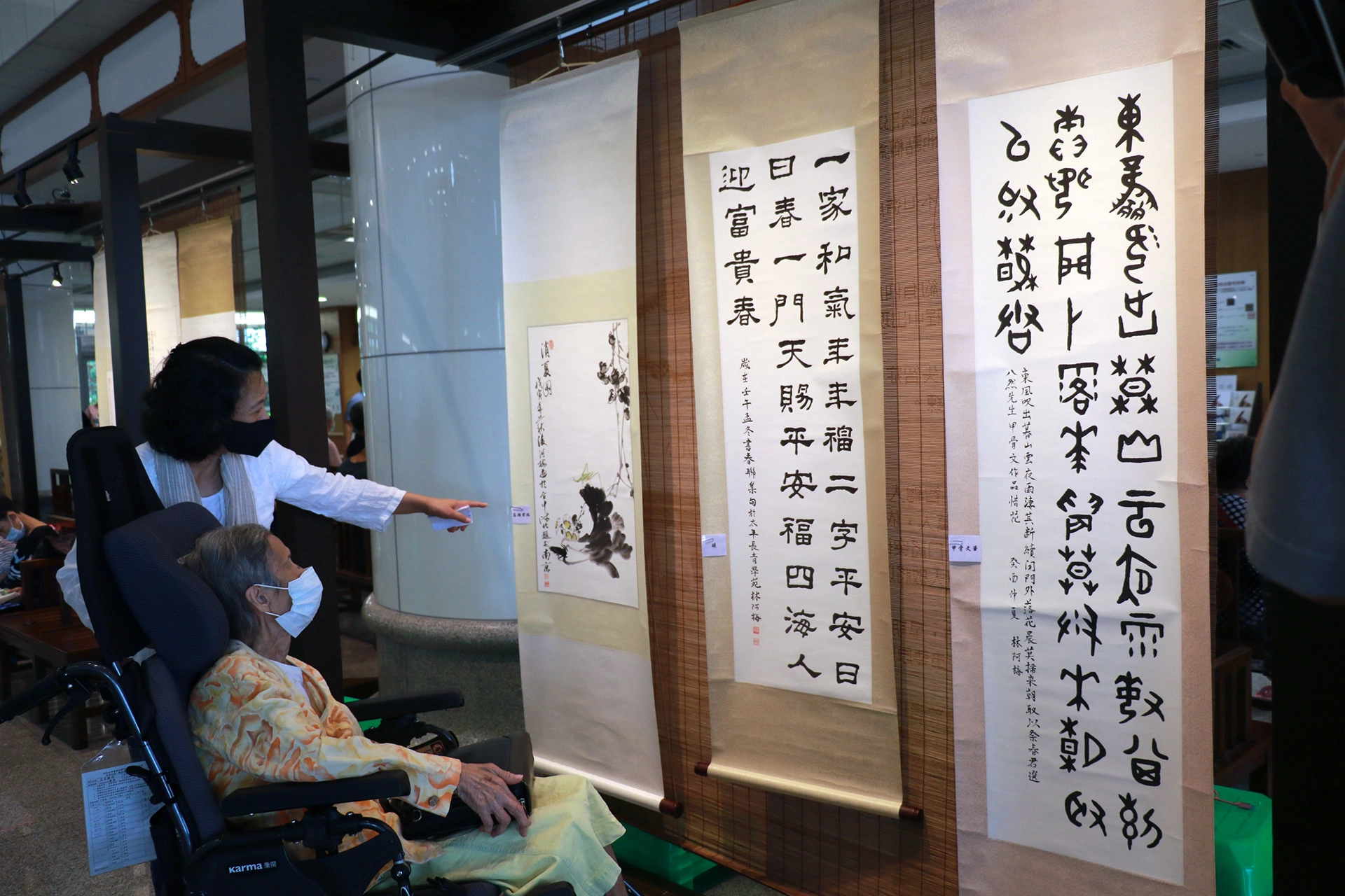 林阿梅與家人欣賞展出畫作。