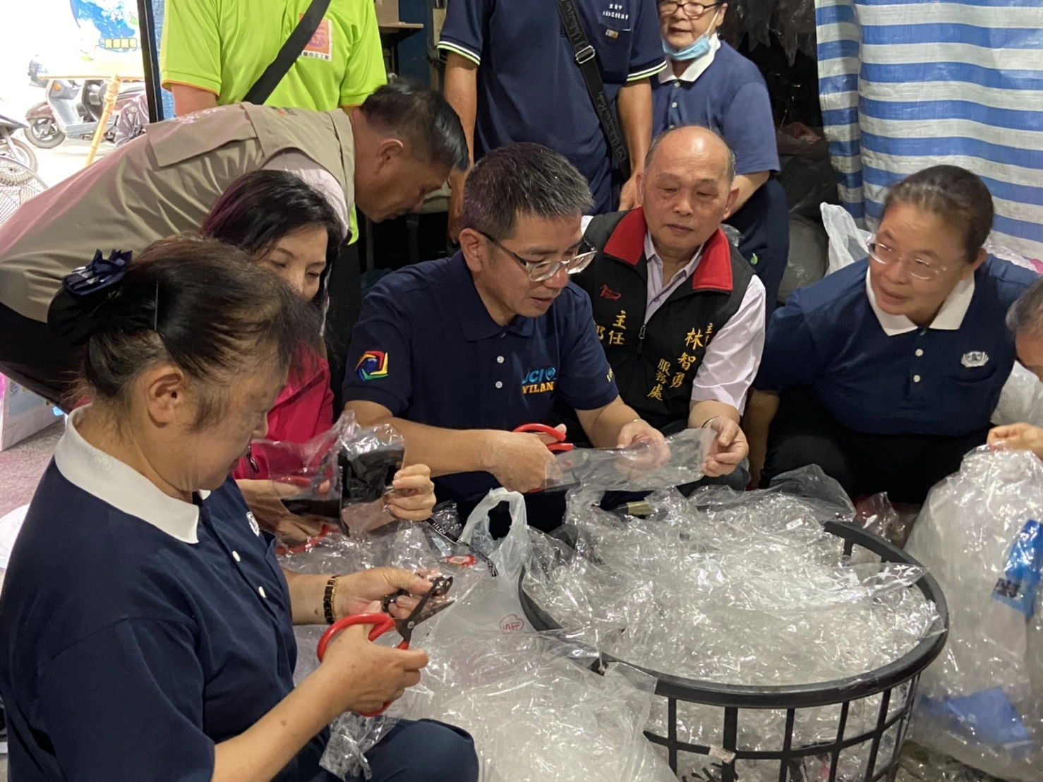 宜蘭市長江聰淵特地前往表揚，並親身體驗剪塑膠袋的工作。(慈濟基金會)