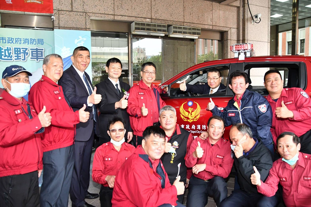徐國勇部長於救災越野車內與受贈團隊合影。