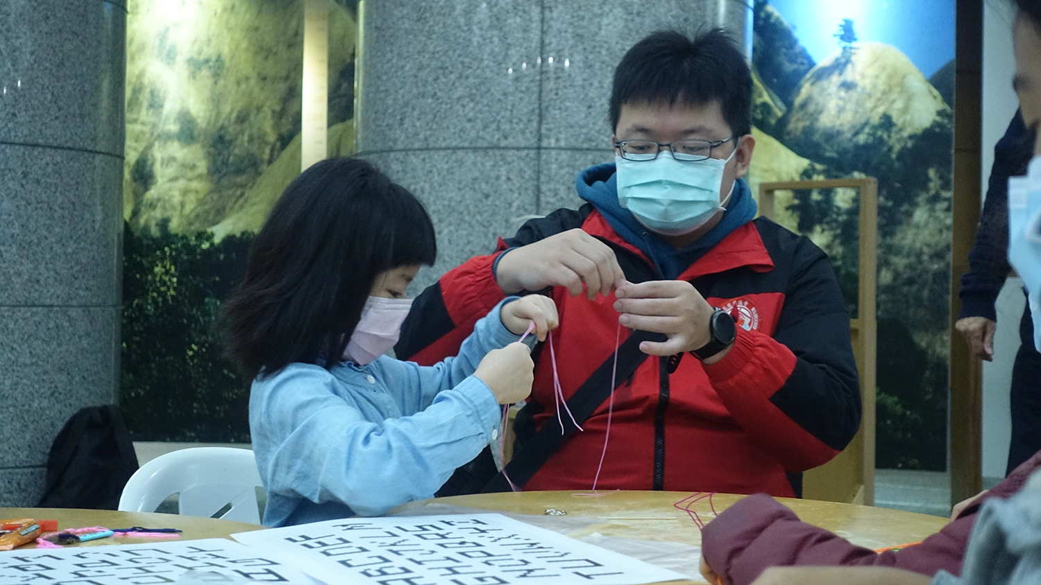 家長帶孩子到場外體驗編繩體驗活動。(圖為慈濟基金會提供)