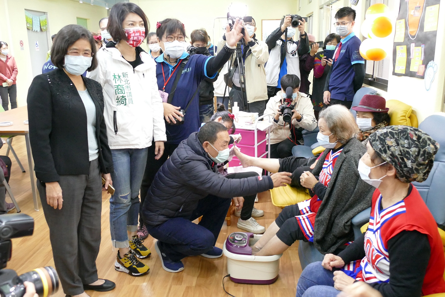 市長到二樓與正在泡腳的長者互動。