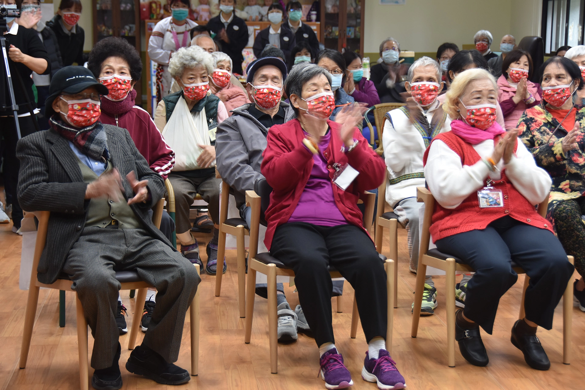 老人家們戴上鮮紅色的口罩跟著唱歌，十分應景。