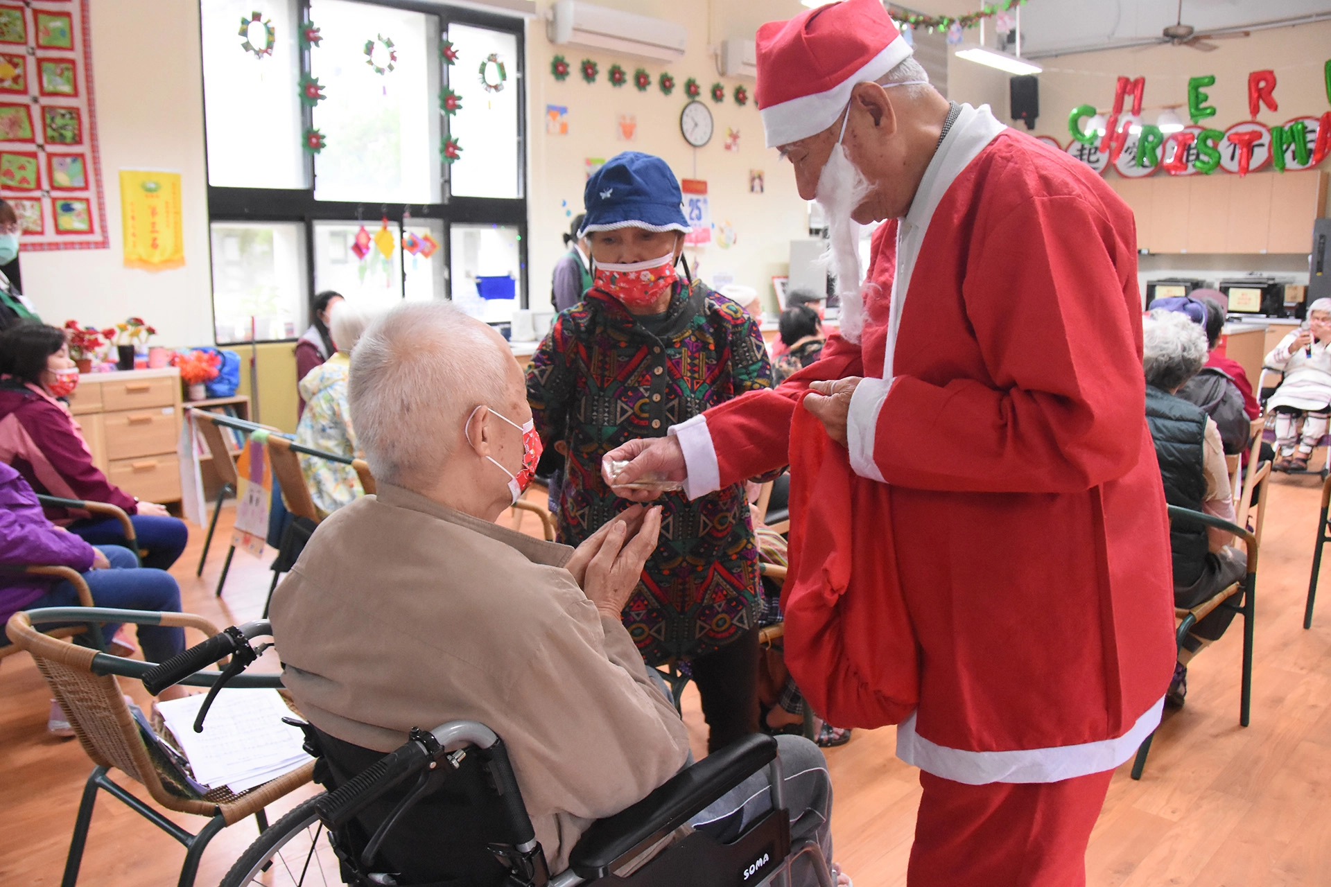 91歲的阿公穿上全套耶誕老公公裝，動作緩慢的發糖果。