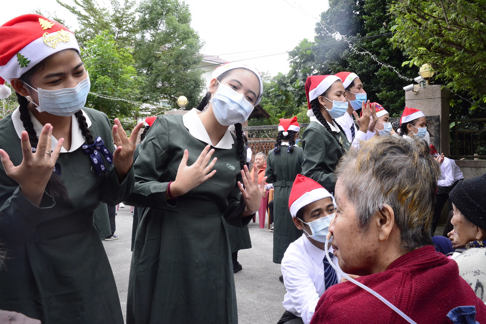 菲律賓學生戴上紅色的耶誕帽，陪伴老人家唱跳。