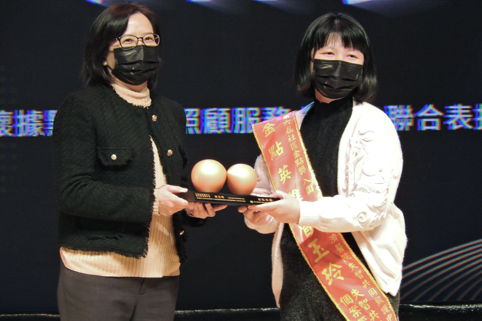 花蓮慈濟醫院失智共同照護中心個管師曾玉玲(右) 由衛福部政務次長李麗芬(左)親自頒獎社區金點獎的長期照顧服務組專業人員之金點英雄個人奬。