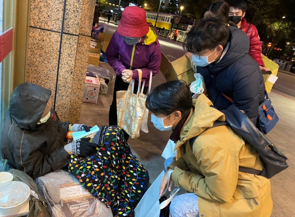 慈濟志工陳雲貞、慈科大校友趙軒、趙悅、張家瑜(左二起)送口罩及暖暖包給街友。