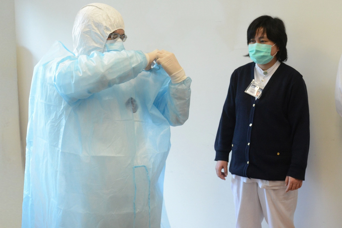 台北慈濟醫院內科加護病房蘇文麟主任於行前示範防護裝備穿脫。