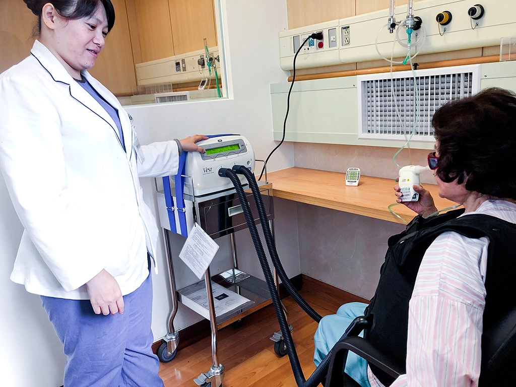 邱桂玲呼吸治療師指導李奶奶進行復健運動。