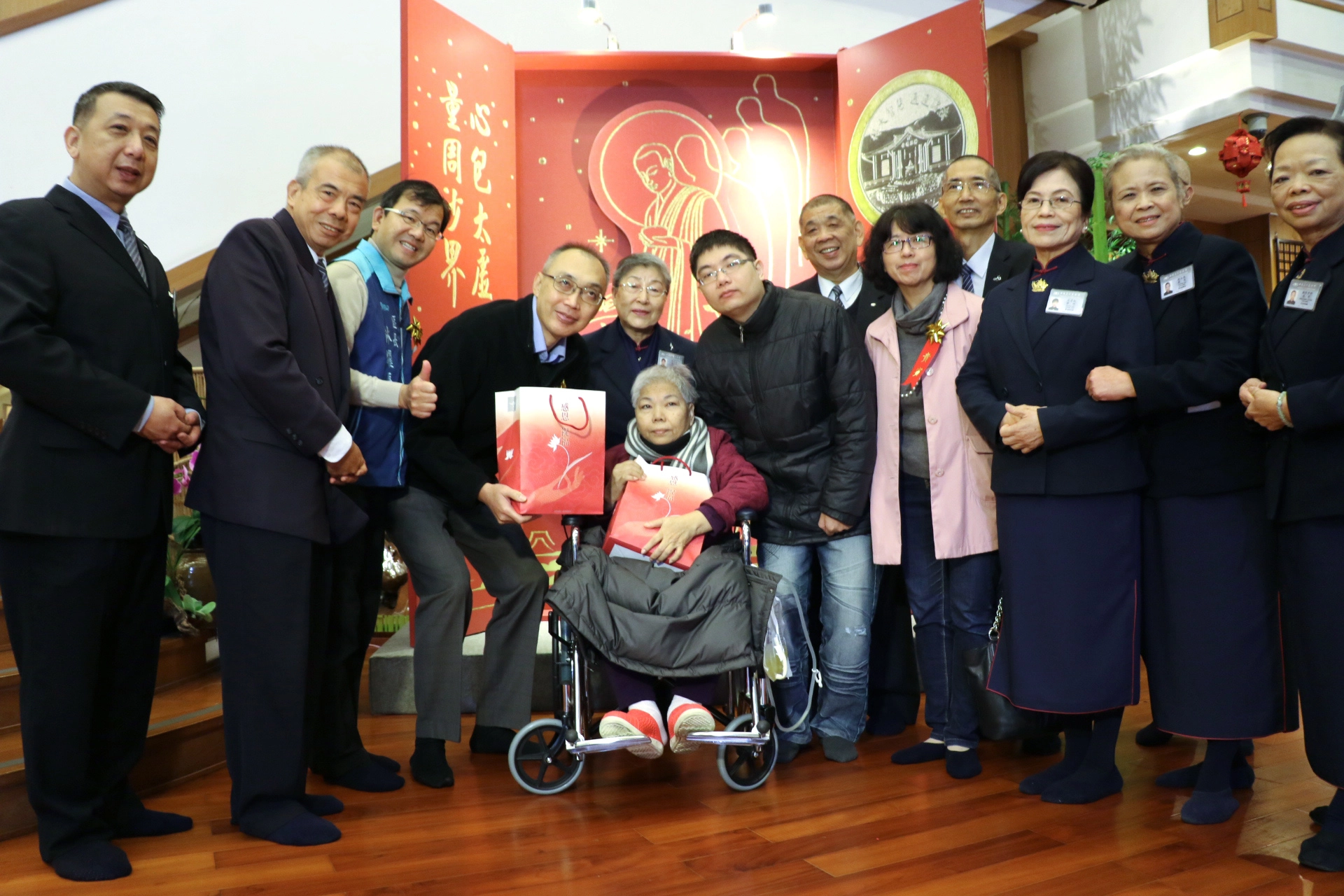 謝政達（左4）和慈濟師兄陳成立（左2）代表致贈福袋和物資卡給關懷戶。
