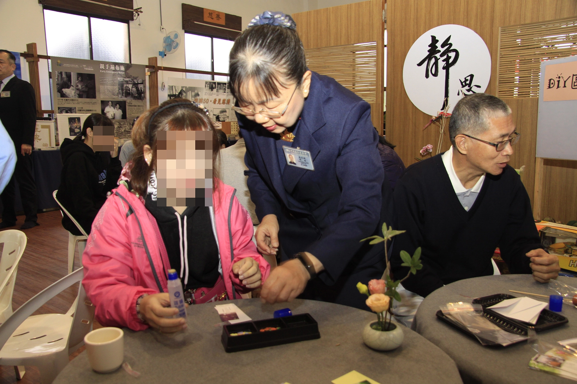 主責志工陳秀嫻陪伴張振華的女兒體驗DIY手做書籤，這也是女兒的興趣之一。