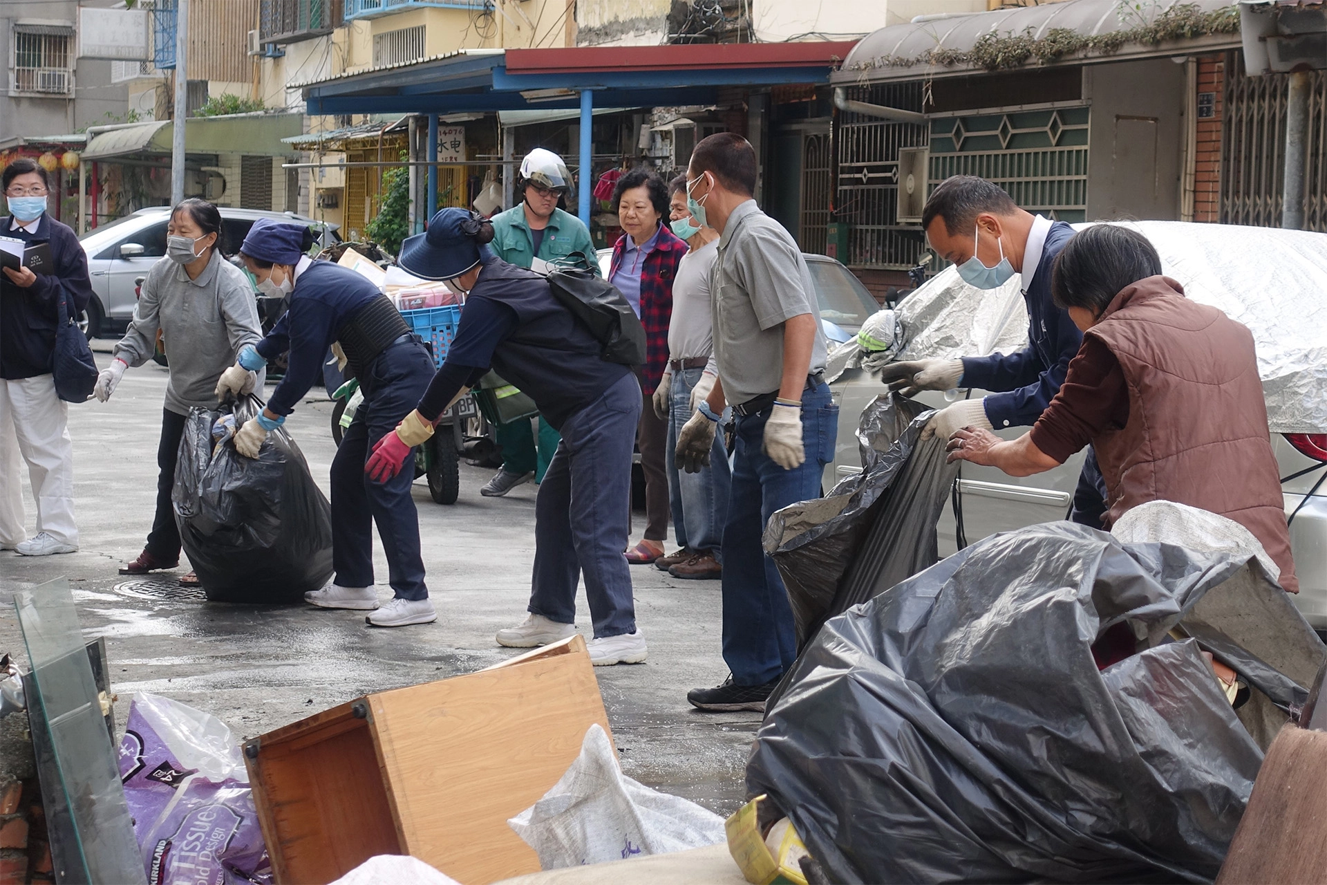 志工一手接一手，將其他小件家具、裝袋後的物品用人龍方式從樓上接到樓下。