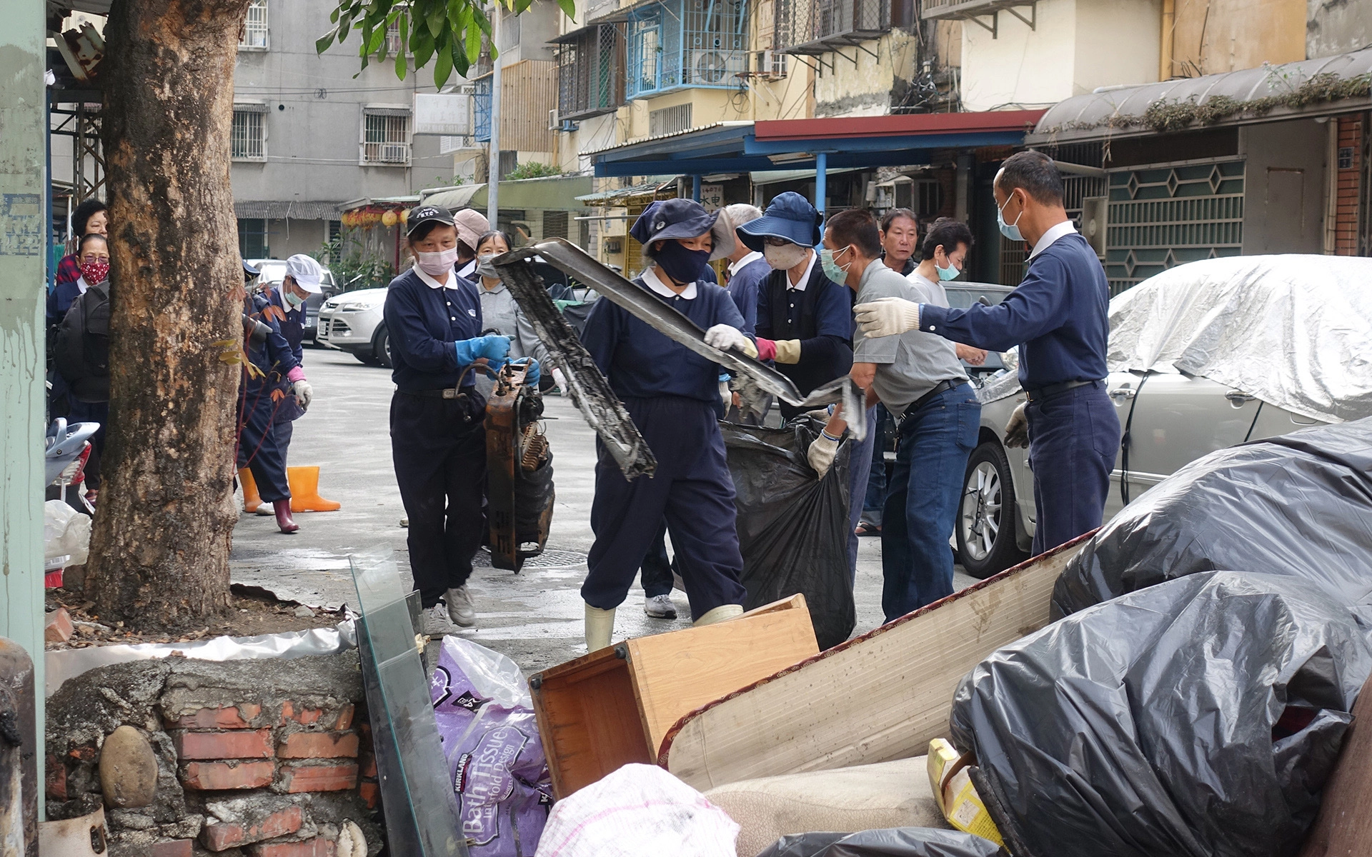 志工一手接一手，將其他小件家具、裝袋後的物品用人龍方式從樓上接到樓下。