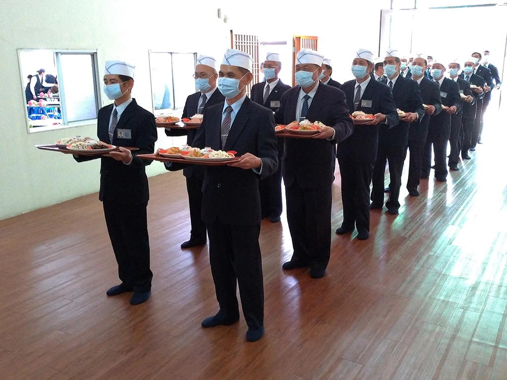 農曆歲末之時，為迎接照顧戶、關懷戶回慈濟大家庭與志工團聚圍爐，在雲林聯絡處席開四十桌；端菜志工整齊列隊，準備上第一道菜。