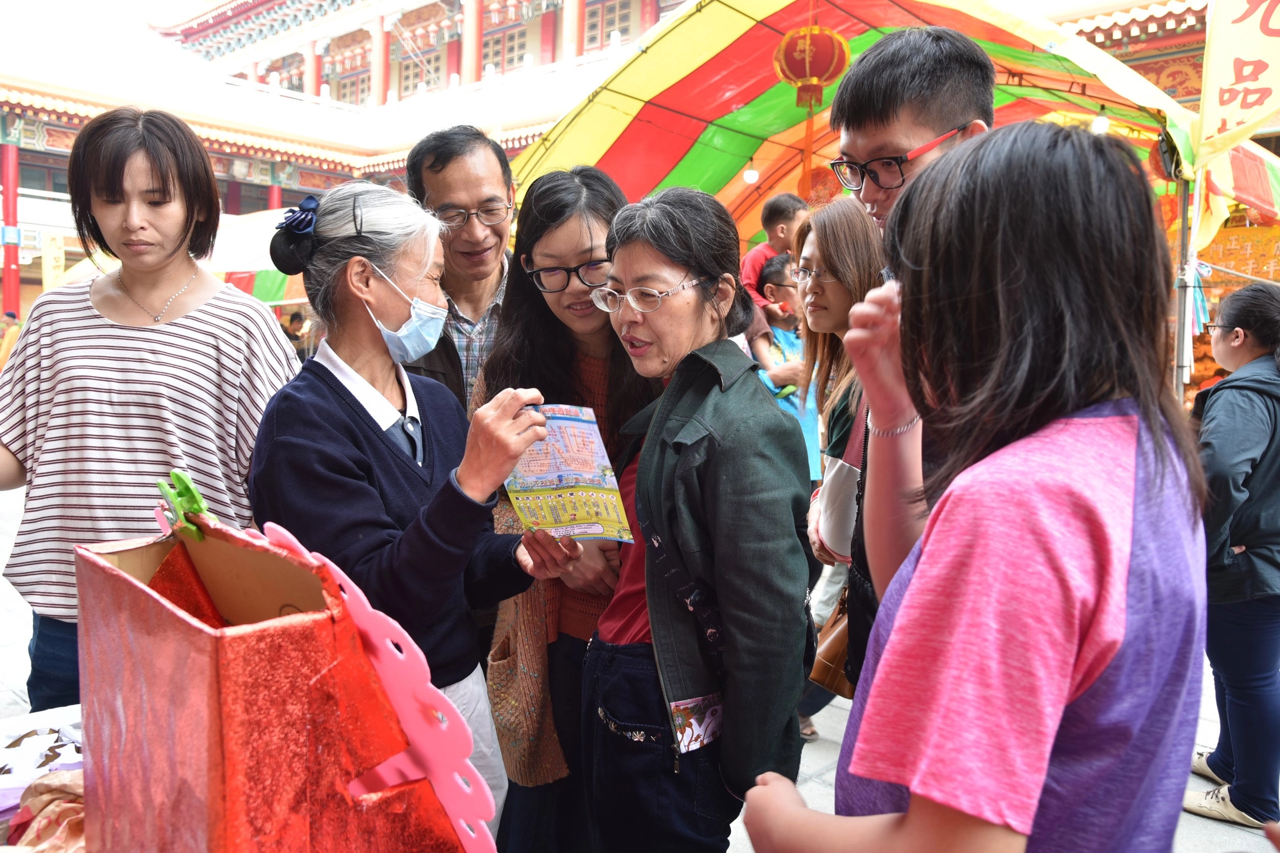 志工拿著環保宣傳DM向民眾說明，了解環保如何落實在生活中。