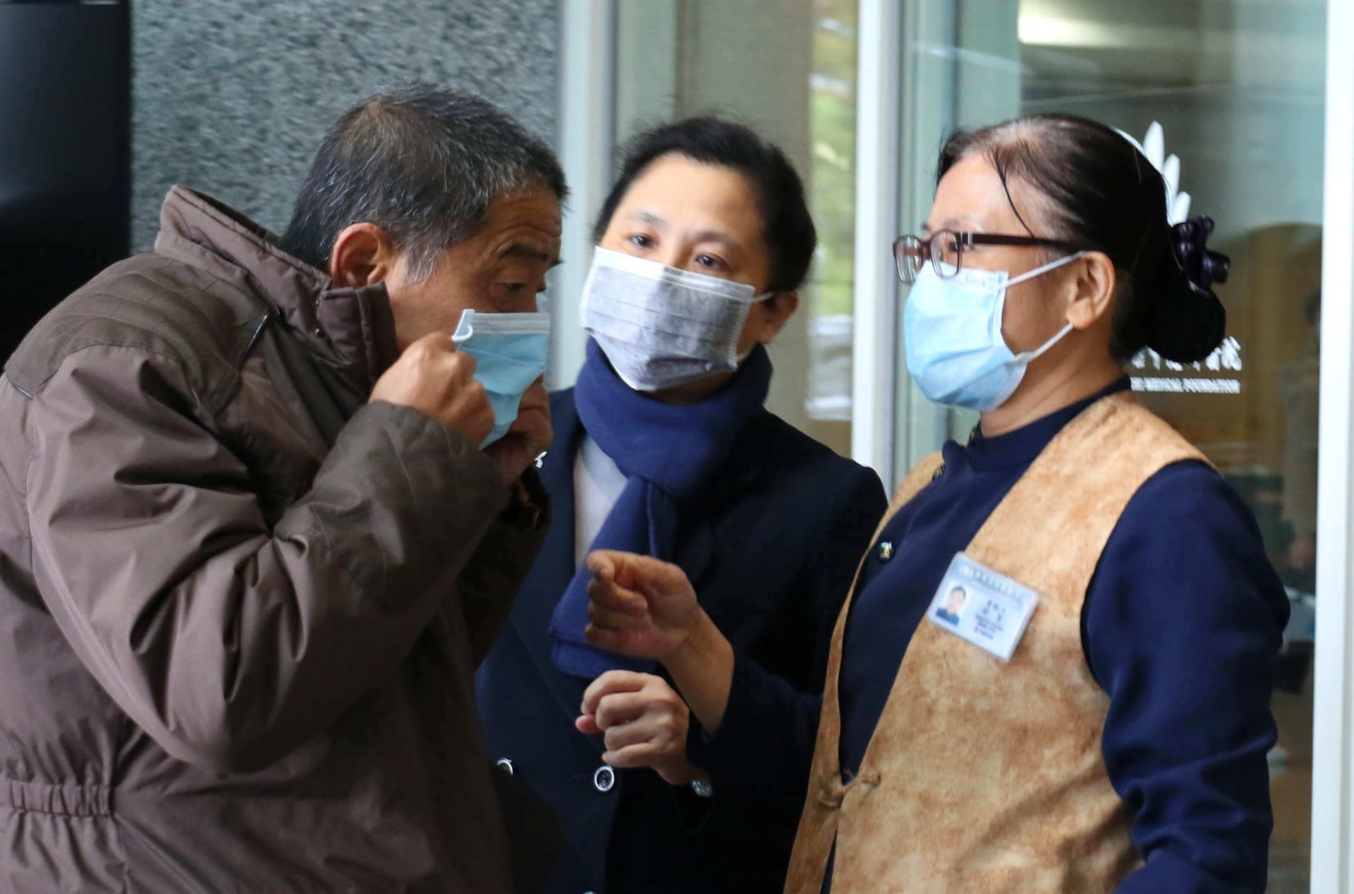 臺中慈濟醫院副院長莊淑婷（中）提醒訪客正確戴口罩。