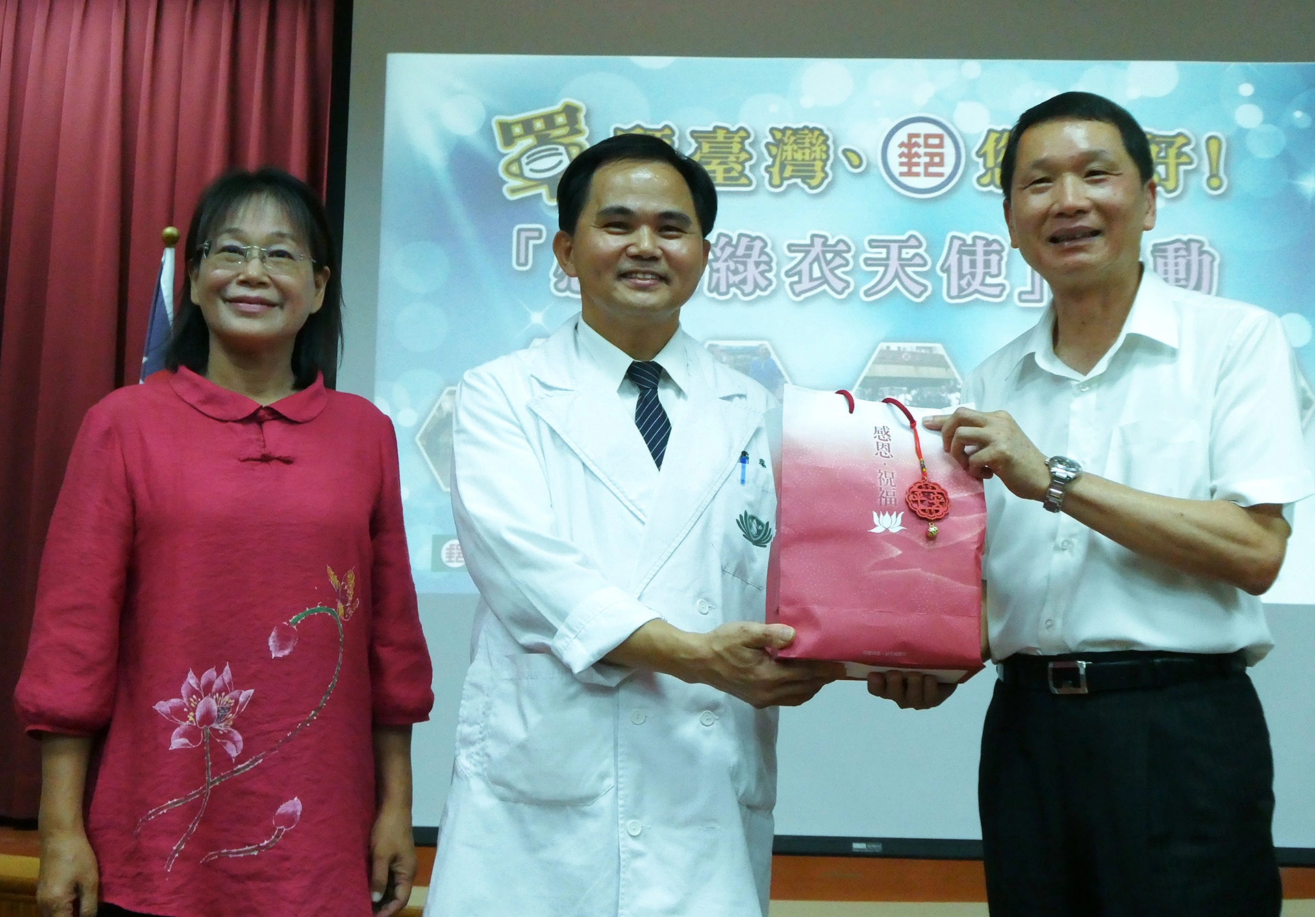 慈濟由斗六慈濟醫院簡瑞騰院長(中)獻上祝福禮給雲林郵局局長吳順吉(右)，由雲林縣謝淑亞副縣長(左)見證。