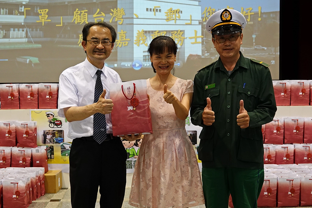 由大林慈濟醫院醫秘林庭光(左)代表致贈500份感恩祝福禮給嘉義郵局副局長謝麗惠(中)。